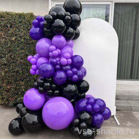Фотозона для поклонников Уэнсдей с пышной фиолетово-чёрной гирляндой